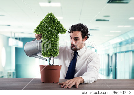 Businessman that watering a plant with a shape of arrow. Concept of growing of company economy . 96093760