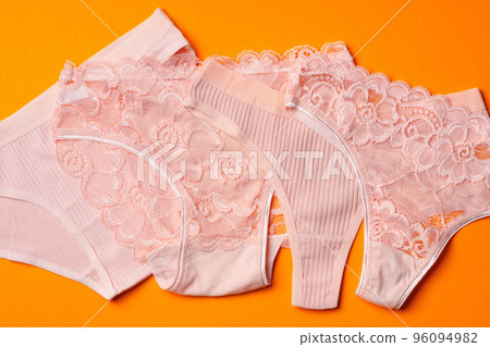 Women's panties on an orange background flat lay 96094982