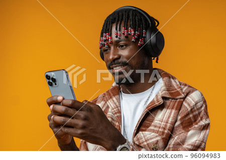 Young african man using smartphone over isolated yellow background Young african man using smartphone over isolated yellow background 96094983