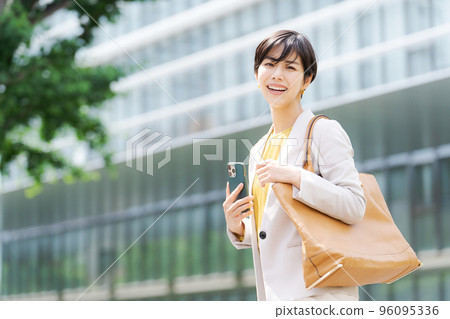 A woman standing in a business district 96095336