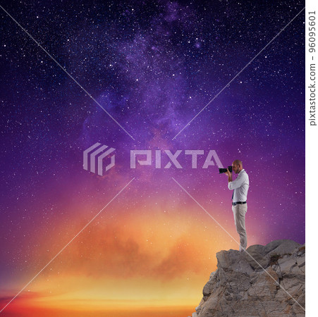 Photographer take a photo in a night sky full of stars Photographer take a photo in a night sky full of stars 96095601