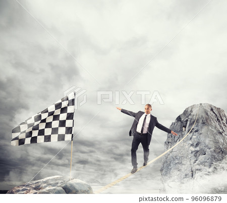 Business concept of businessman who overcome the problems reaching the flag on a rope 96096879