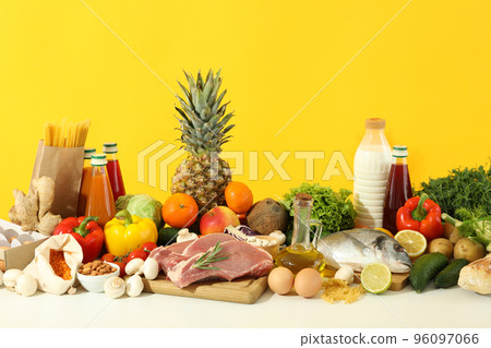 Grocery on white table against yellow background Grocery on white table against yellow background 96097066