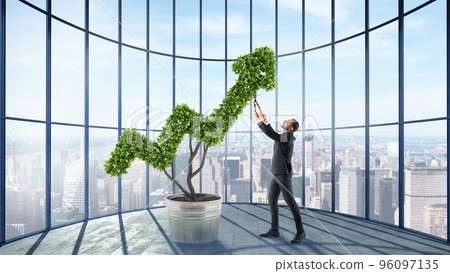 Businessman cares for a big plant shaped as an arrow Businessman cares for a big plant shaped as an arrow 96097135