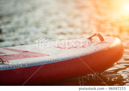 Close up of a stand up paddle board SUP and paddle on a dock Close up of a stand up paddle board SUP and paddle on a dock 96097255