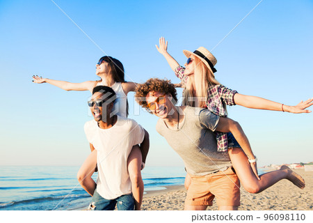 Happy smiling couples playing at the beach 96098110