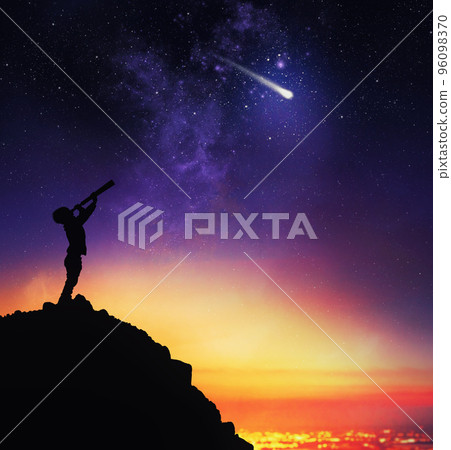 Child observes starry sky with a telescope 96098370