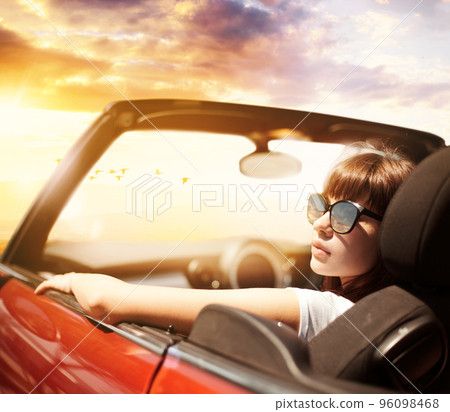 Young woman in cabriolet car near sea Young woman in cabriolet car near sea 96098468