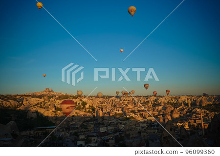 Sunrise panoramic view to Goreme city and flying balloons, Cappadocia, Turkey Sunrise panoramic view to Goreme city and flying balloons, Cappadocia, Turkey 96099360
