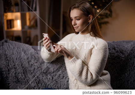 Woman using mobile on couch 96099623