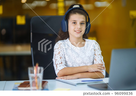 Online education. School girl using laptop computer studying through online e-learning system. Online education. School girl using laptop computer studying through online e-learning system. 96099836