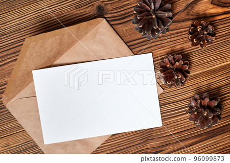 Open envelope with blank letterhead on wooden background with Pine cones Open envelope with blank letterhead on wooden background with Pine cones 96099873