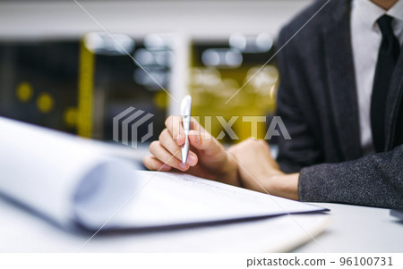 Pen in office worker hand. Close up of the hands of a businessman in a suit signing a document. Pen in office worker hand. Close up of the hands of a businessman in a suit signing a document. 96100731