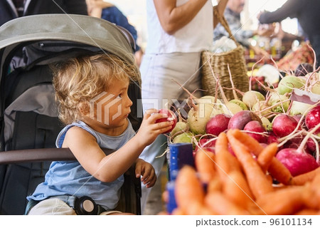 Cute boy with his mother buying fresh vegetables at the farmer's market 96101134