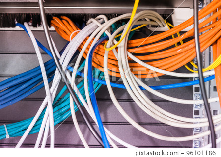 bunch of patch network cables sorted in rack cabinet, leading from patch panel in the server rack in the data center room bunch of patch network cables sorted in rack cabinet, leading from patch panel in the server rack in the data center room 96101186