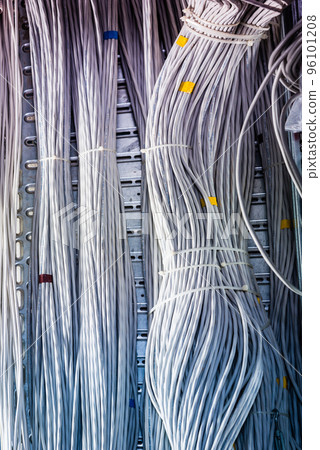 detail of large number of ethernet cables tied together connecting racks inside server room 96101208