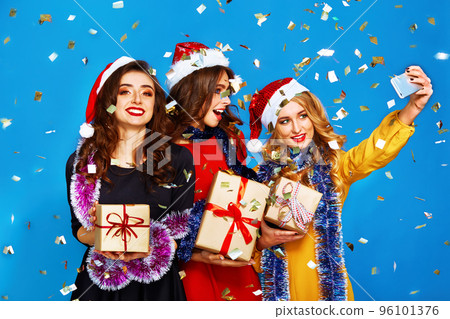 portrait of three happy young women in santa claus hat with gift .Christmas concept. portrait of three happy young women in santa claus hat with gift .Christmas concept. 96101376