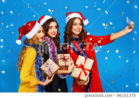 portrait of three happy young women in santa claus hat with gift .Christmas concept. portrait of three happy young women in santa claus hat with gift .Christmas concept. 96101378