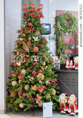 Christmas souvenirs and toys for decoration prepared for sale in store. Variety of colorful decoration in shopping center. New Year. 96102321