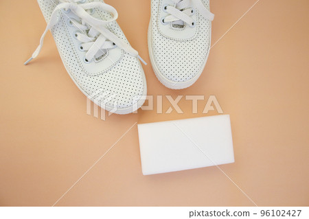 White sneakers with a melamine sponge on a beige background. 96102427