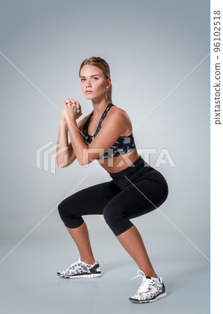 Fitness woman in sports clothing doing sit-ups, studio shot 96102518
