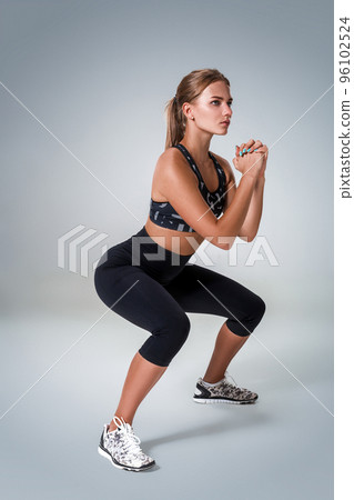 Fitness woman in sports clothing doing sit-ups, studio shot Fitness woman in sports clothing doing sit-ups, studio shot 96102524