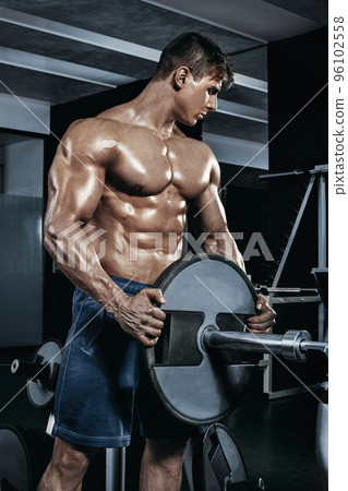 Male bodybuilder, fitness model trains in the gym Male bodybuilder, fitness model trains in the gym 96102558