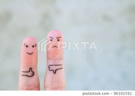 Fingers art of couple. Woman showing thumbs up and man showing thumbs down. Concept of disagreement in family. 96102591