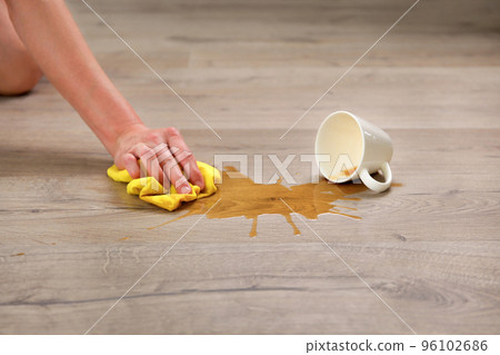 A cup of coffee fell on laminate, coffee spilled on floor. 96102686