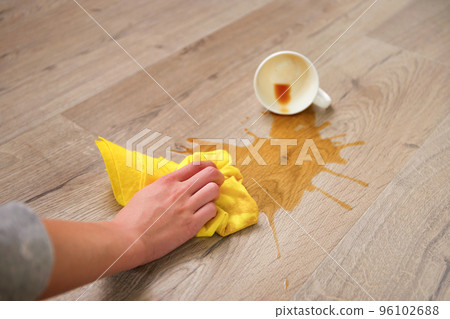 A cup of coffee fell on laminate, coffee spilled on floor. A cup of coffee fell on laminate, coffee spilled on floor. 96102688