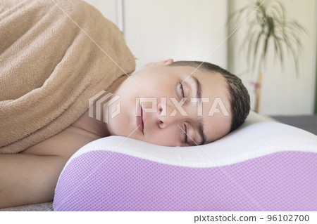 Orthopedic pillow helps to get rid of wrinkles on face. Cosmetology and dermatology. Person sleeps on right pillow, helping the face to maintain beauty and prevents the appearance of deep wrinkles. Orthopedic pillow helps to get rid of wrinkles on face. Cosmetology and dermatology. Person sleeps on right pillow, helping the face to maintain beauty and prevents the appearance of deep wrinkles. 96102700