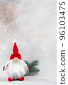 Xmas gnome in red hat with fir branch holiday card on light winter background 96103475