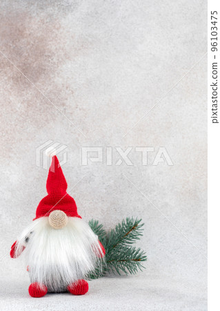 Xmas gnome in red hat with fir branch holiday card on light winter background 96103475