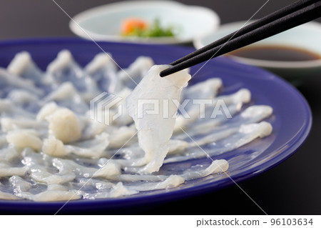 用筷子夾起河豚生魚片 用筷子夾起河豚生魚片 96103634