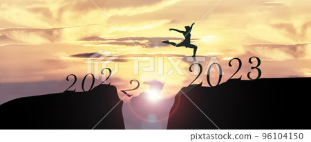 2023 Happy New Year concept, Young woman Jumping across the gap of the mountain from Old year 2022 to 2023 New Year.. 2023 Happy New Year concept, Young woman Jumping across the gap of the mountain from Old year 2022 to 2023 New Year.. 96104150