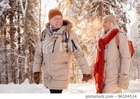 Senior Couple Holding Hands in Winter Forest Senior Couple Holding Hands in Winter Forest 96104514