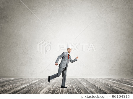 King businessman in elegant suit running in empty room 96104515