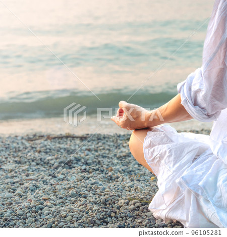 Woman meditating at the Garda Lake. Sunset. 96105281