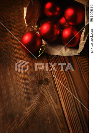 Red christmas balls in a box on a wooden table 96105656