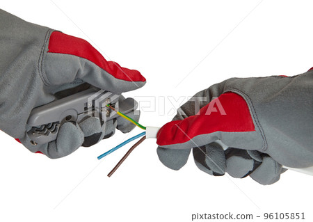 Electrician removes insulation from a three-core copper wire with a stripper 96105851