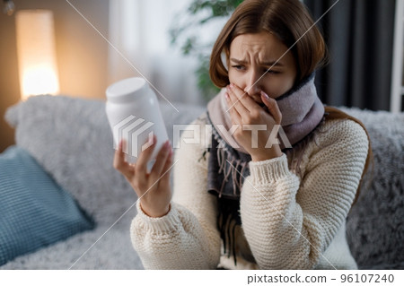 Sick woman with pills on sofa Sick woman with pills on sofa 96107240
