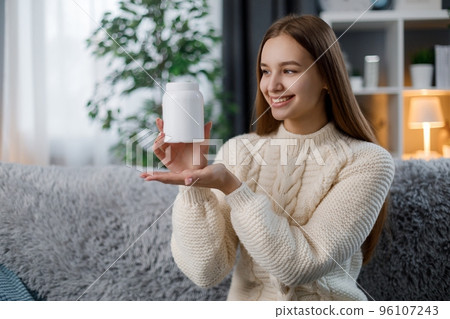 Woman with pills on sofa 96107243