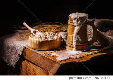 Wooden beer mug with beer and foam standing on a wooden table Wooden beer mug with beer and foam standing on a wooden table 96109157