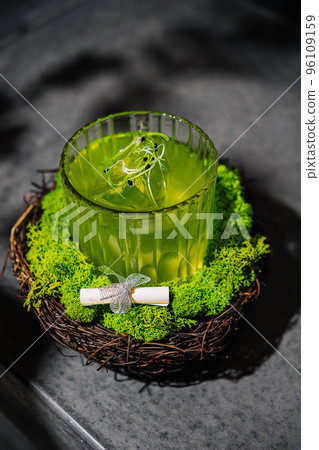 A green alcoholic drink in a clear glass A green alcoholic drink in a clear glass 96109159