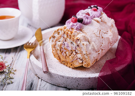 Meringue roll pavlova cake with cream and berries 96109182