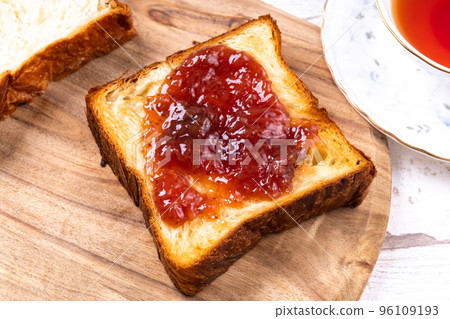 Spread strawberry jam on Danish bread Spread strawberry jam on Danish bread 96109193