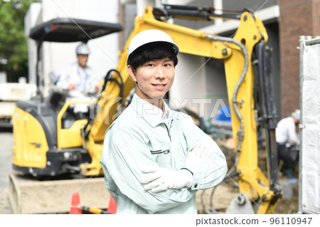 在建築工地工作的雙臂交叉的年輕男工 在建築工地工作的雙臂交叉的年輕男工 96110947