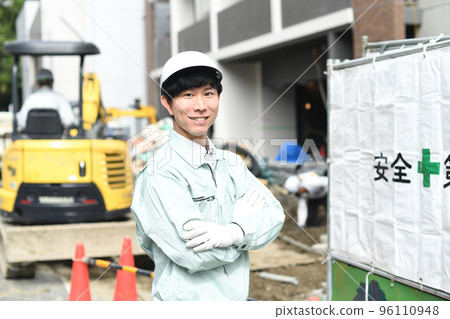 Young male worker with folded arms working at construction site 96110948