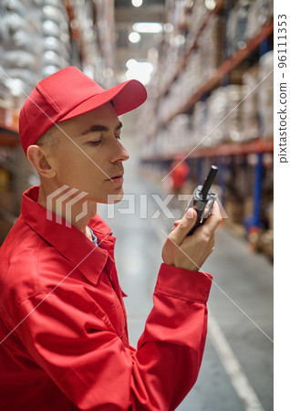 Worker using the two-way radio in the storage area 96111353