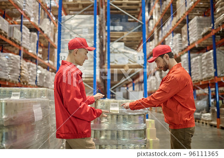 Experienced loaders unloading merchandise in the storage area 96111365